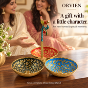 Three-bowl bird stand on a walnut console in a warm gifting scene, with two women in the background.