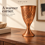 Engraved copper goblet styled on a walnut console.