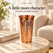 Tall engraved glass styled on a cream side table.